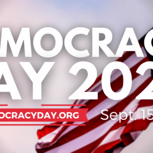 DECORATION ONLY: White text against a background photo of the American flag. The text reads, "DEMOCRACY DAY 2023: Sept. 15, 2023 | usdemocracyday.org"